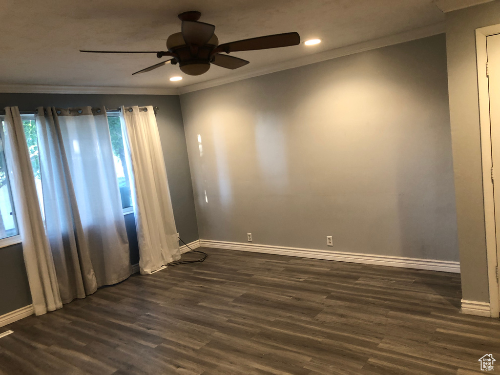 Spare room with crown molding, ceiling fan, baseboards, recessed lighting, and dark wood finished floors