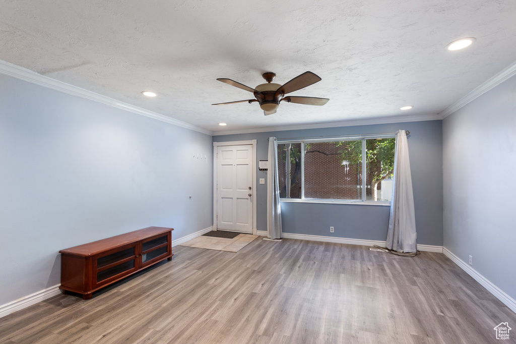 Entrance foyer with wood finished floors, ceiling fan, recessed lighting, and crown molding