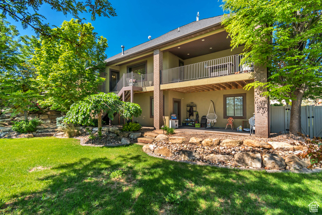 Rear view of property with a balcony, stucco siding, and a patio area