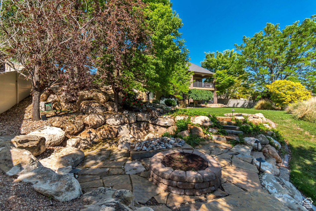 View of yard featuring a balcony and an outdoor fire pit