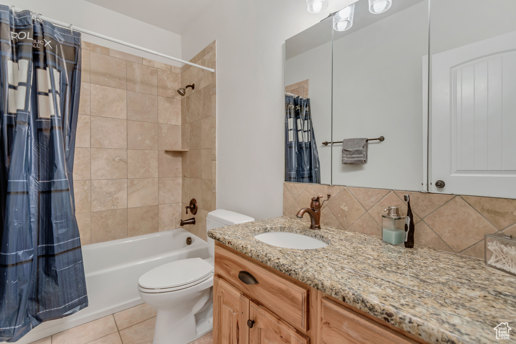 Full bathroom with toilet, vanity, shower / bath combination with curtain, tasteful backsplash, and tile patterned flooring