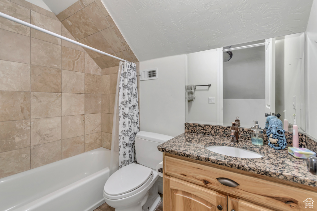 Full bath featuring vanity, toilet, shower / bathtub combination with curtain, and vaulted ceiling