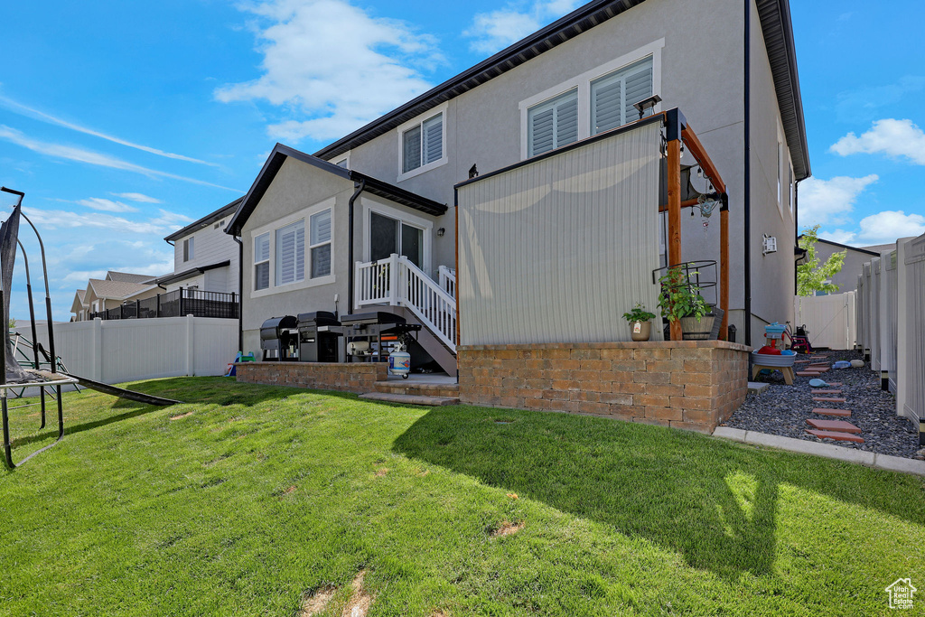 Back of property with a trampoline and stucco siding