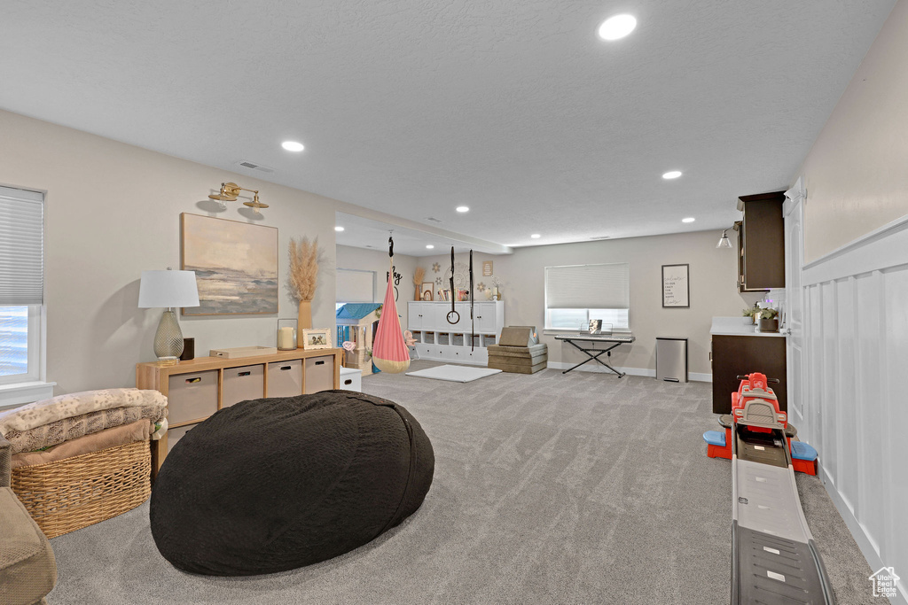 Recreation room featuring light colored carpet, recessed lighting, healthy amount of natural light, and baseboards