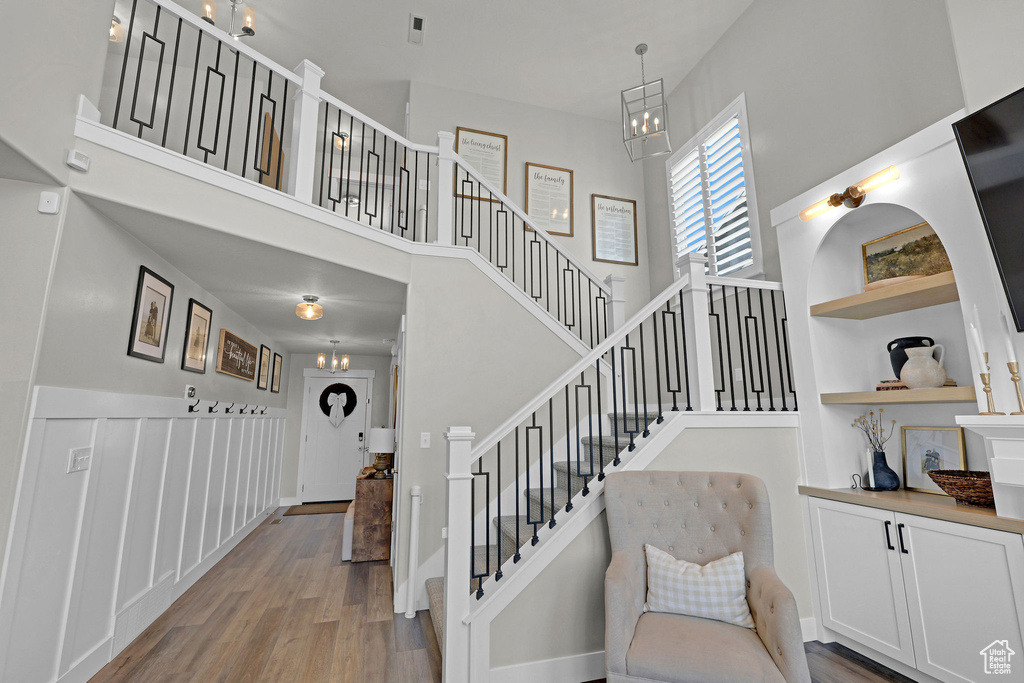Staircase with a towering ceiling and wood finished floors