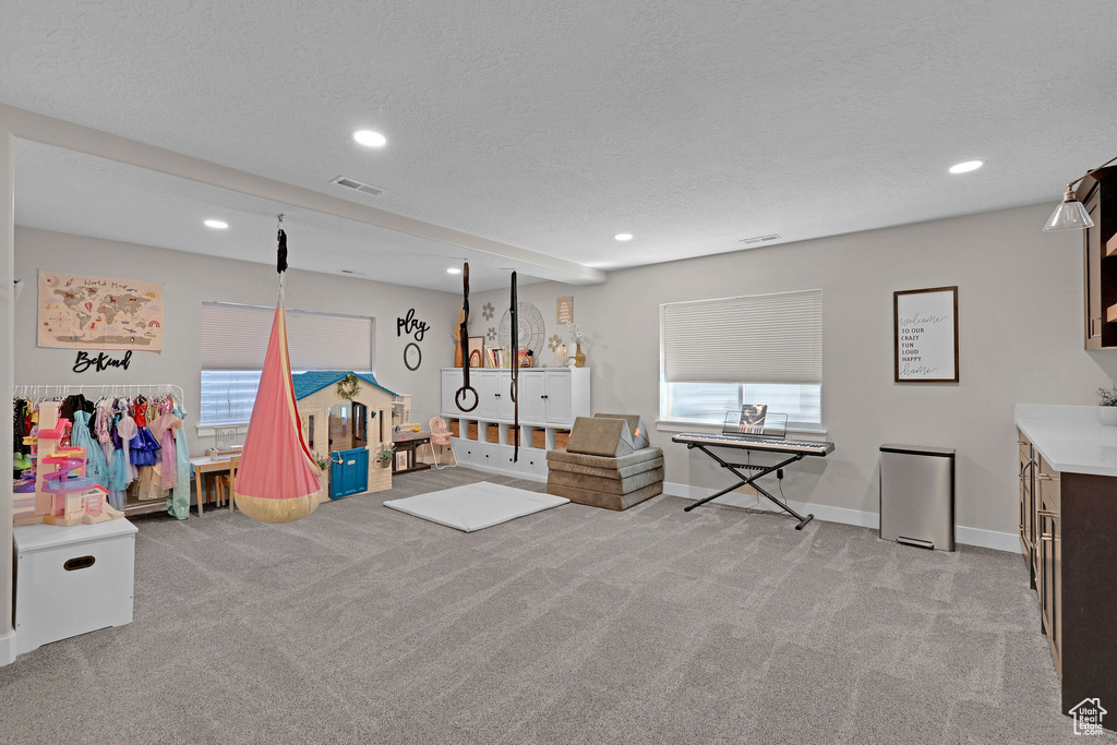 Playroom featuring light colored carpet, recessed lighting, baseboards, and a textured ceiling