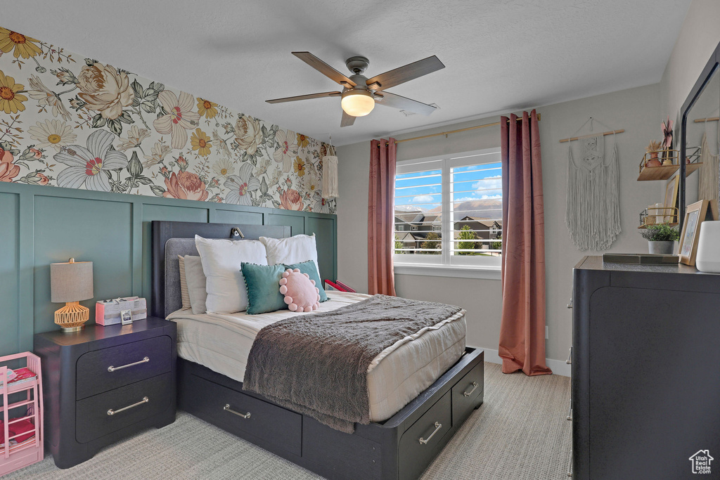 Bedroom featuring ceiling fan, wallpapered walls, and light colored carpet
