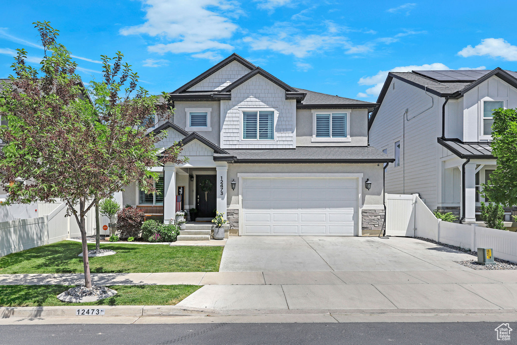 Craftsman inspired home with driveway, an attached garage, and stone siding