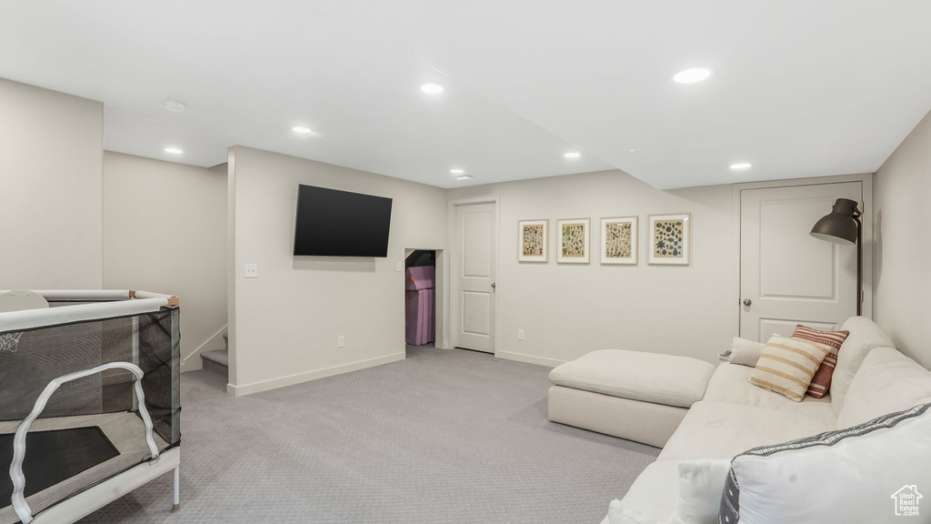 Living area featuring baseboards, light colored carpet, and recessed lighting