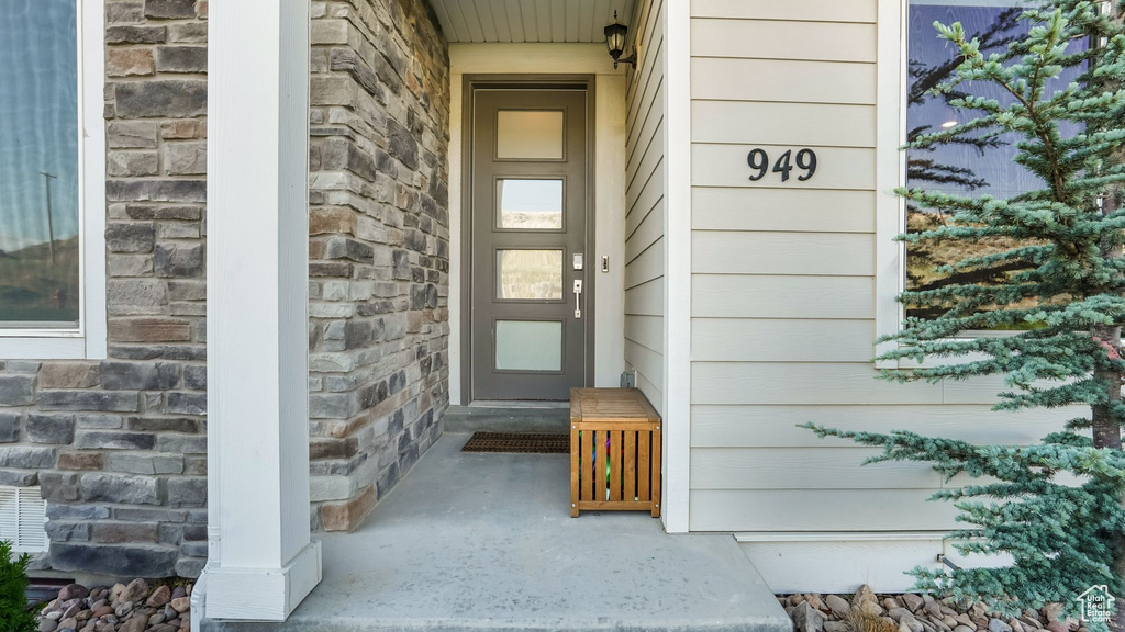 Entrance to property featuring stone siding and covered porch