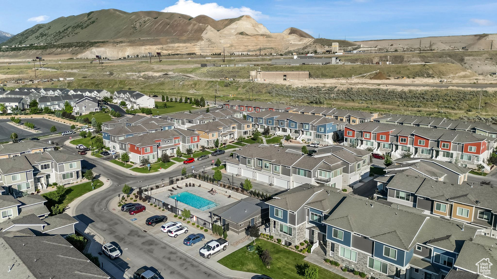 Aerial overview of property\'s location featuring nearby suburban area, a mountainous background, and a pool area