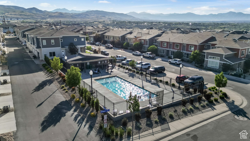Aerial perspective of suburban area with a pool and a mountain backdrop