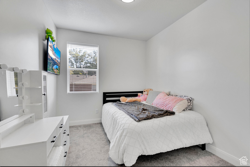 Bedroom with light carpet and baseboards