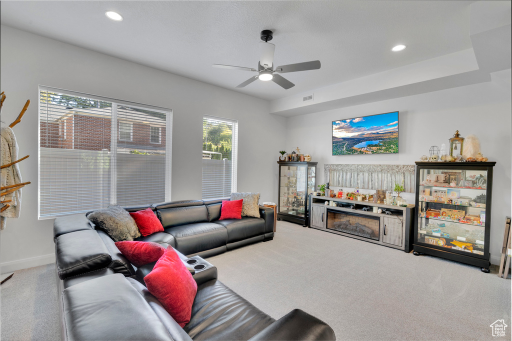 Carpeted living area with a ceiling fan, baseboards, and recessed lighting