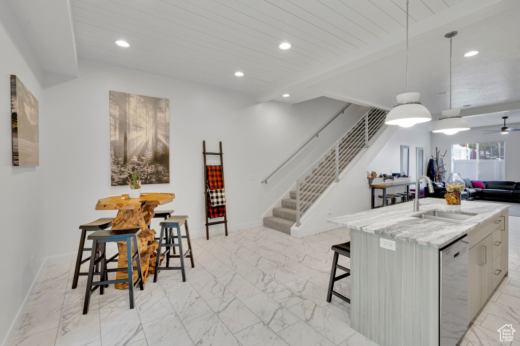 Kitchen with dishwasher, a sink, light marble finish floors, recessed lighting, and open floor plan