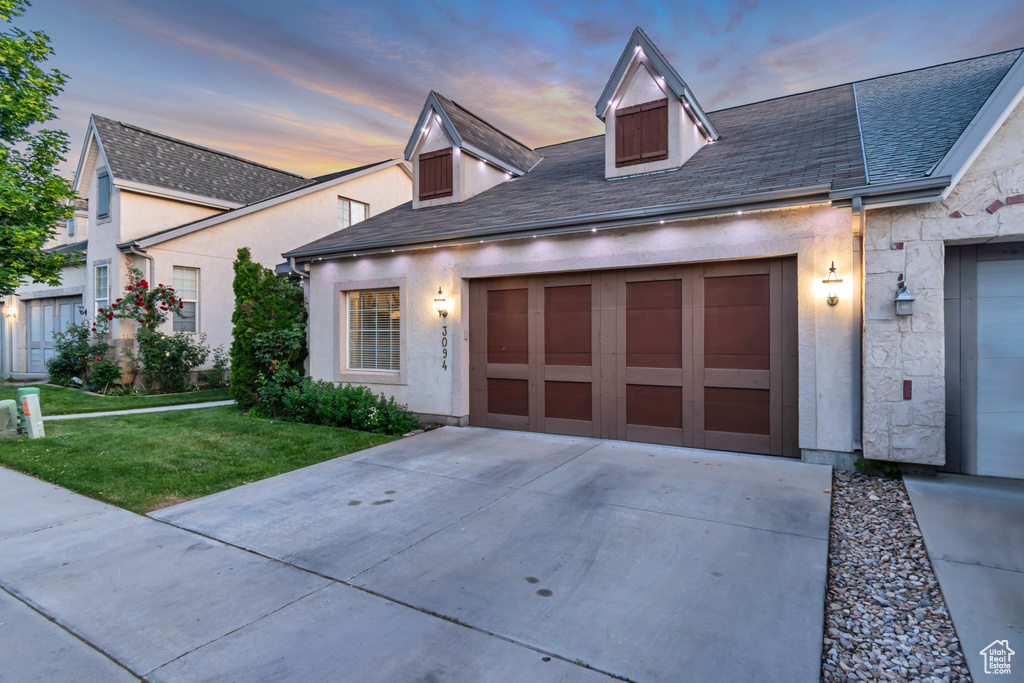 View of front of property with concrete driveway, a front lawn, a garage, and stucco siding