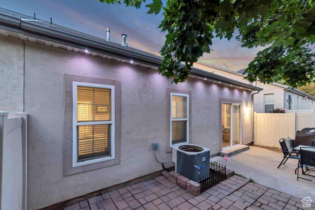 Patio terrace at dusk featuring central AC unit and a patio area