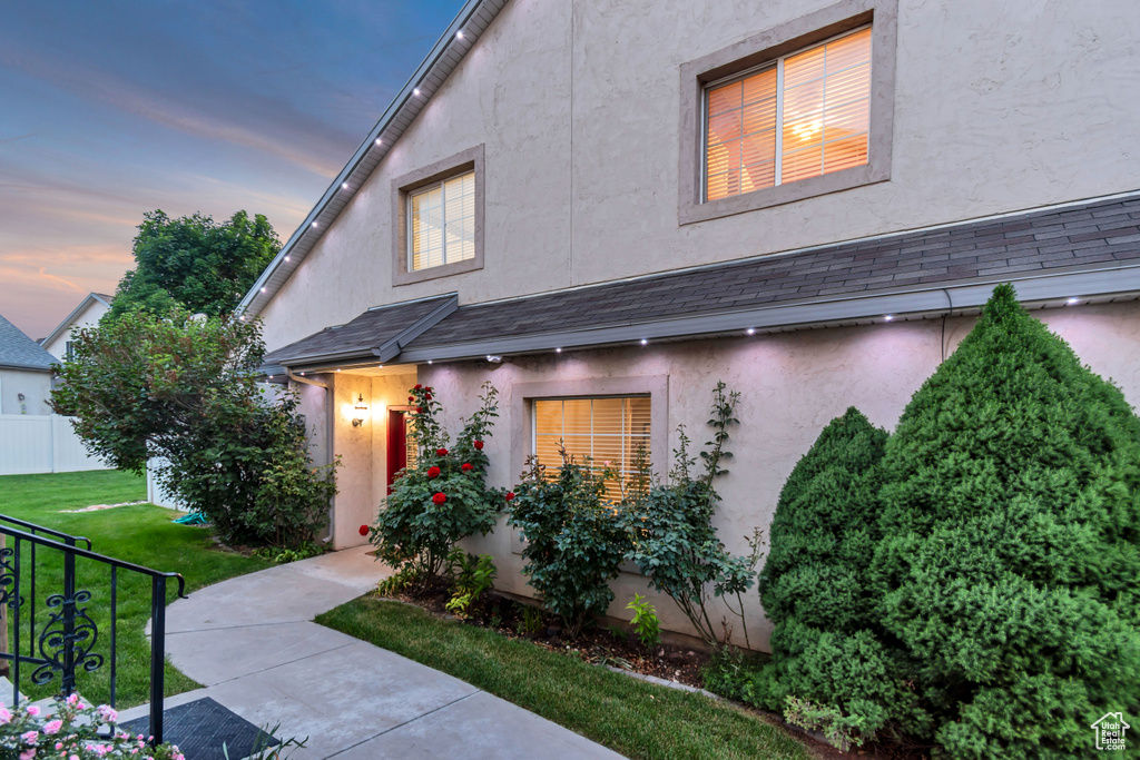 View of front of house featuring stucco siding and a yard