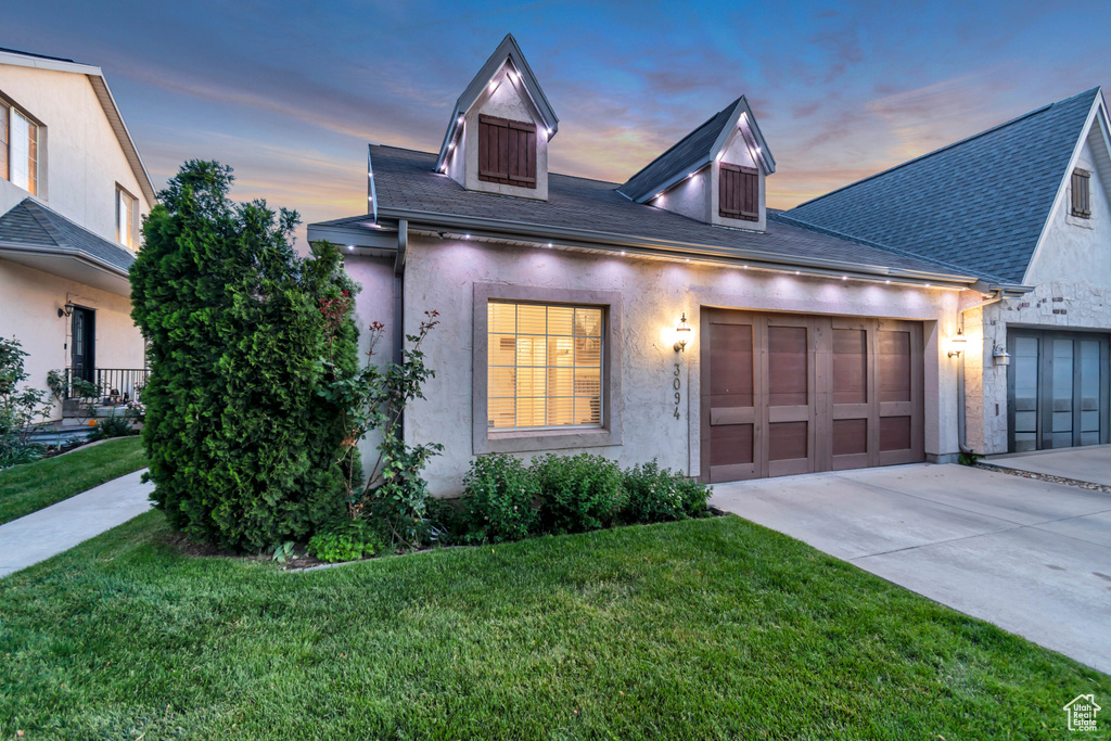 View of front of home with concrete driveway, a garage, a front yard, and stucco siding