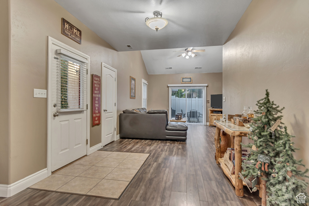 Entrance foyer featuring ceiling fan, wood finished floors, vaulted ceiling, and baseboards