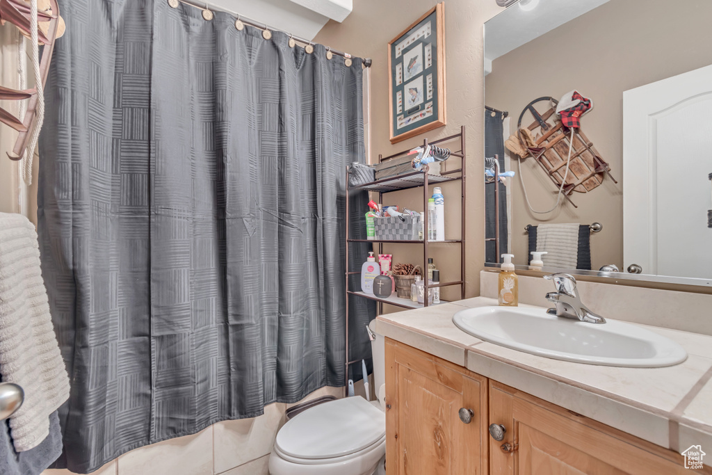 Bathroom with vanity, toilet, and shower / bath combination with curtain
