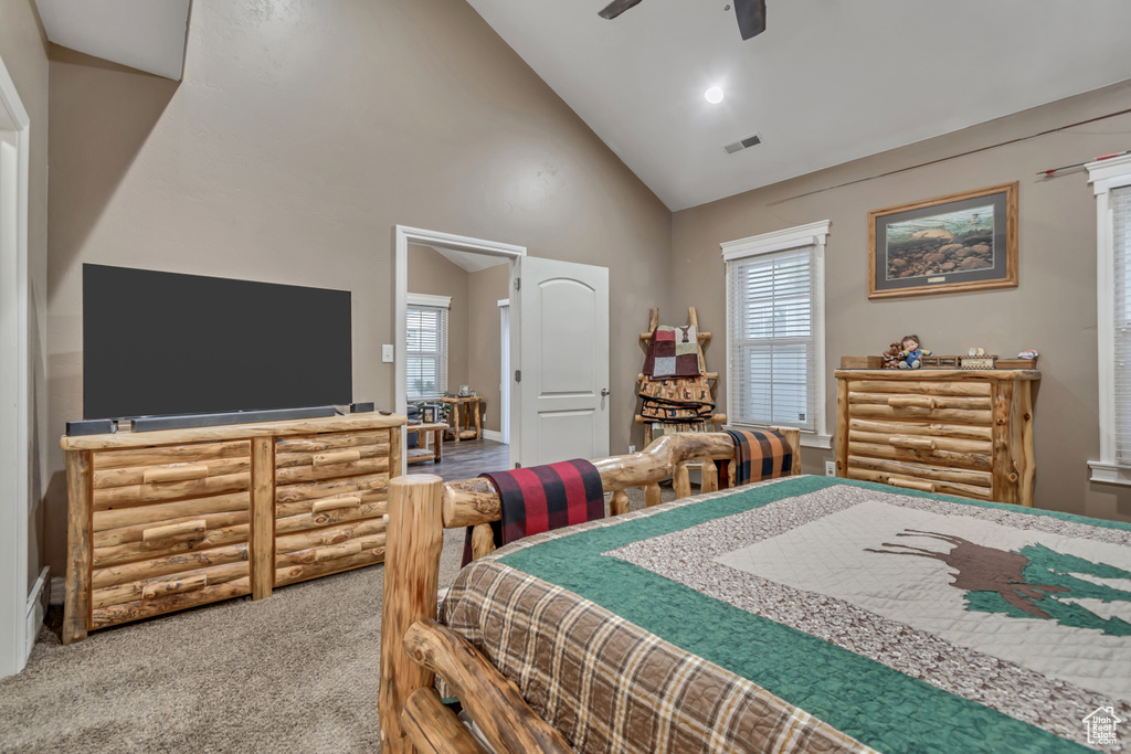 Carpeted bedroom featuring high vaulted ceiling and ceiling fan