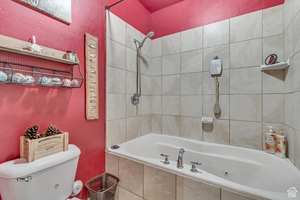 Bathroom with toilet and a combined bath / shower with jetted tub