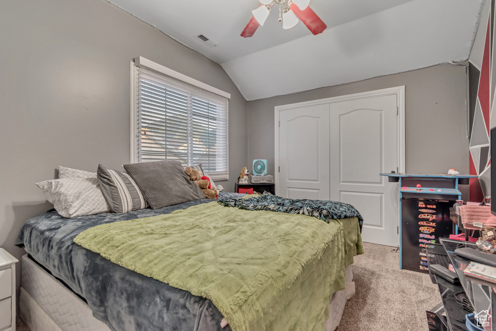 Bedroom featuring lofted ceiling, a closet, carpet flooring, and ceiling fan