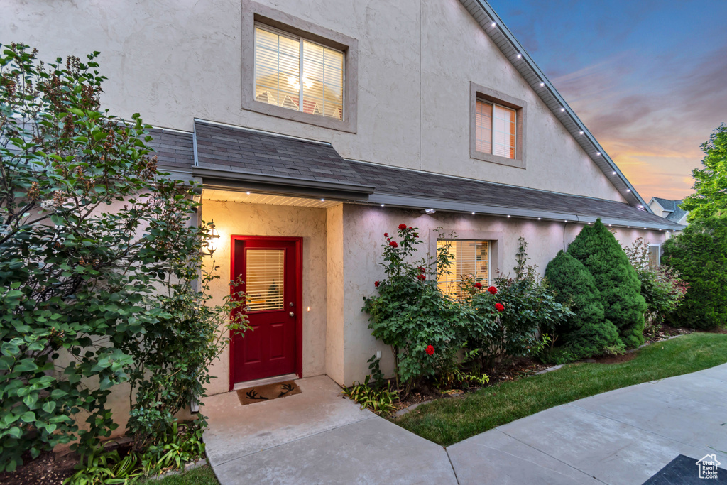 Exterior entry at dusk featuring stucco siding