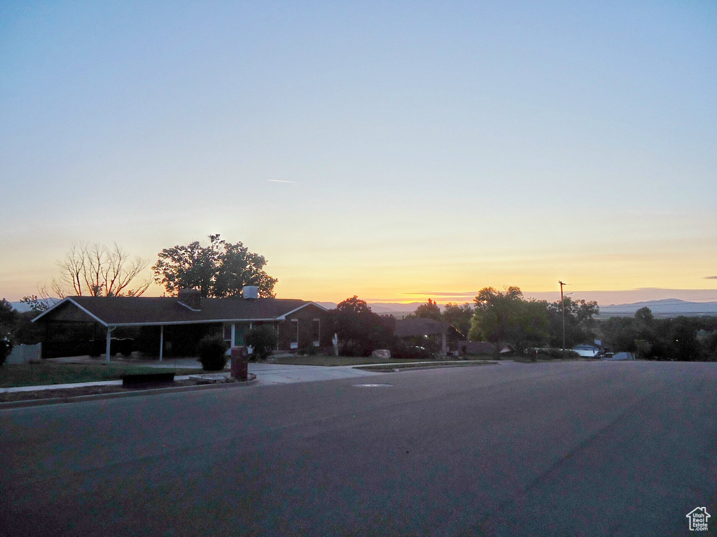 View of asphalt street with street lighting, sidewalks, and curbs