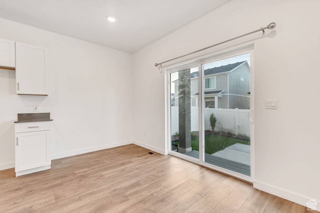 Unfurnished dining area with light wood-style floors, baseboards, and recessed lighting