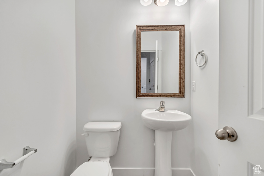 Half bath with toilet and baseboards