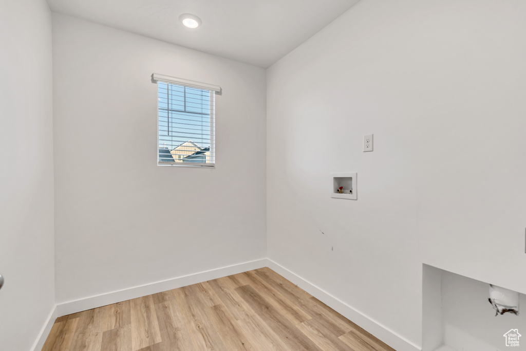 Washroom featuring hookup for a washing machine, light wood-style flooring, and baseboards