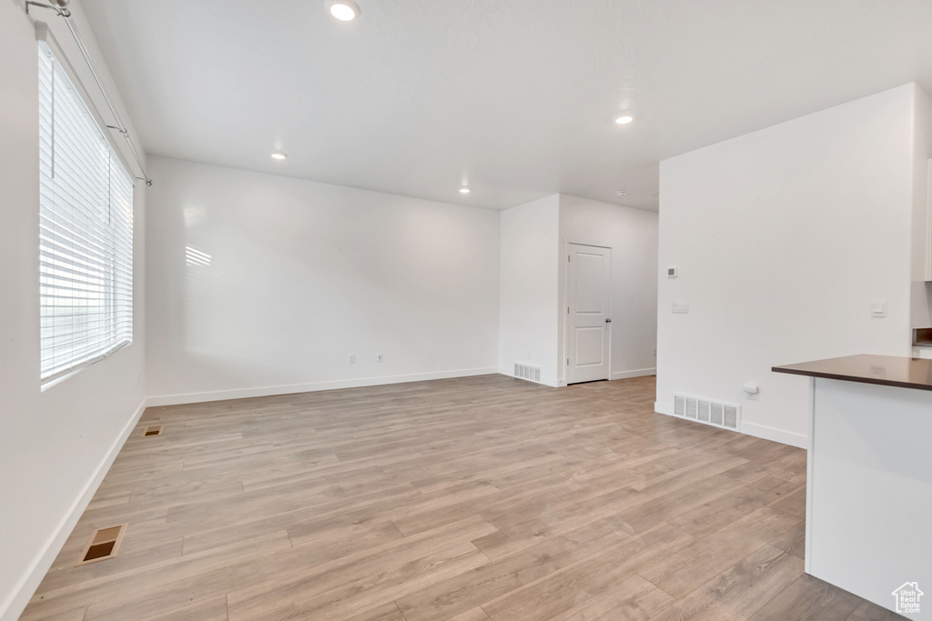 Empty room with light wood-style flooring, baseboards, and recessed lighting