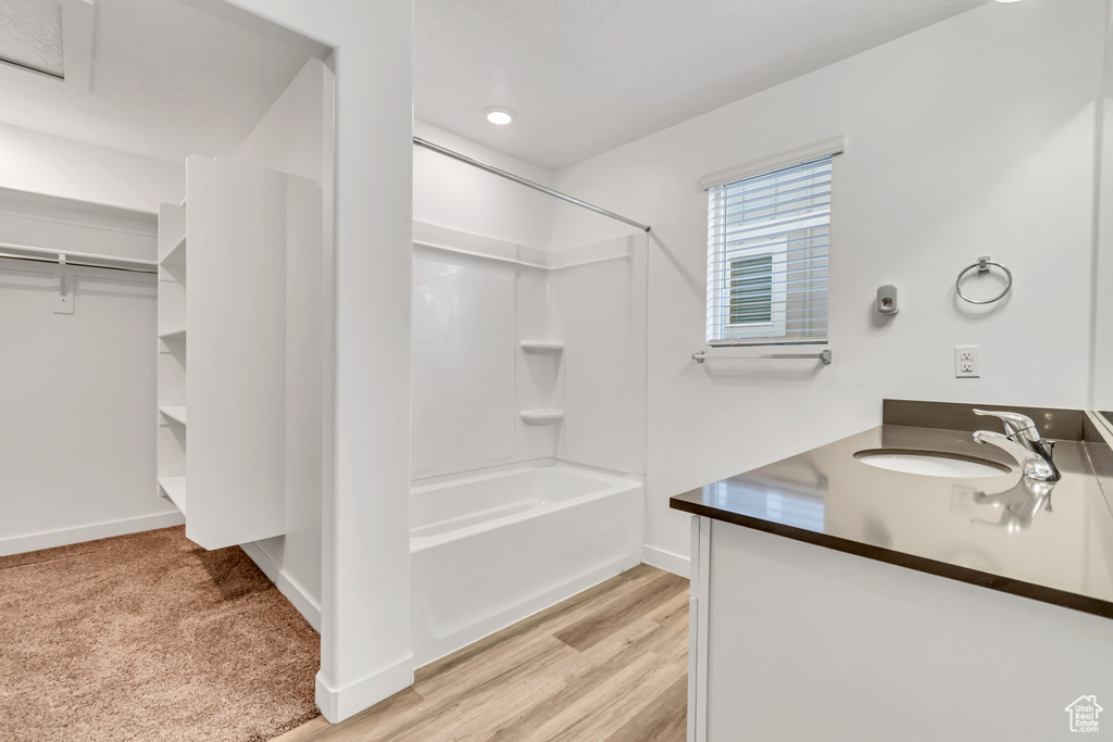 Bathroom with  shower combination, vanity, baseboards, and wood finished floors