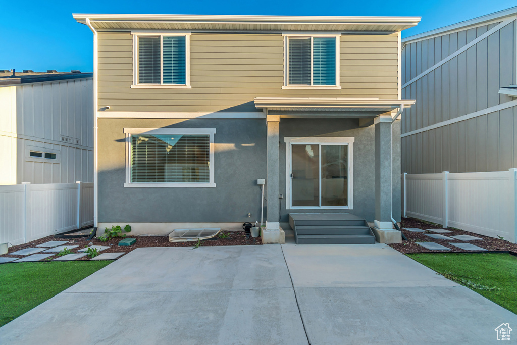 View of front of home with a patio, a fenced backyard, entry steps, and stucco siding