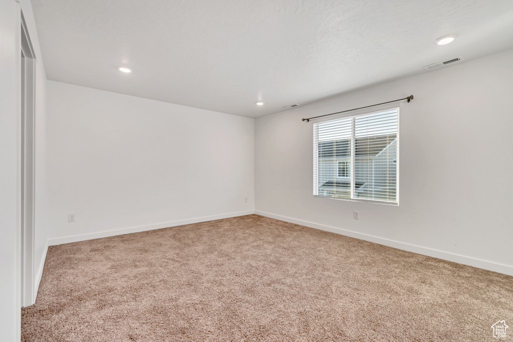 Carpeted empty room with recessed lighting and baseboards