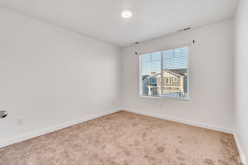 Unfurnished room with light carpet and baseboards