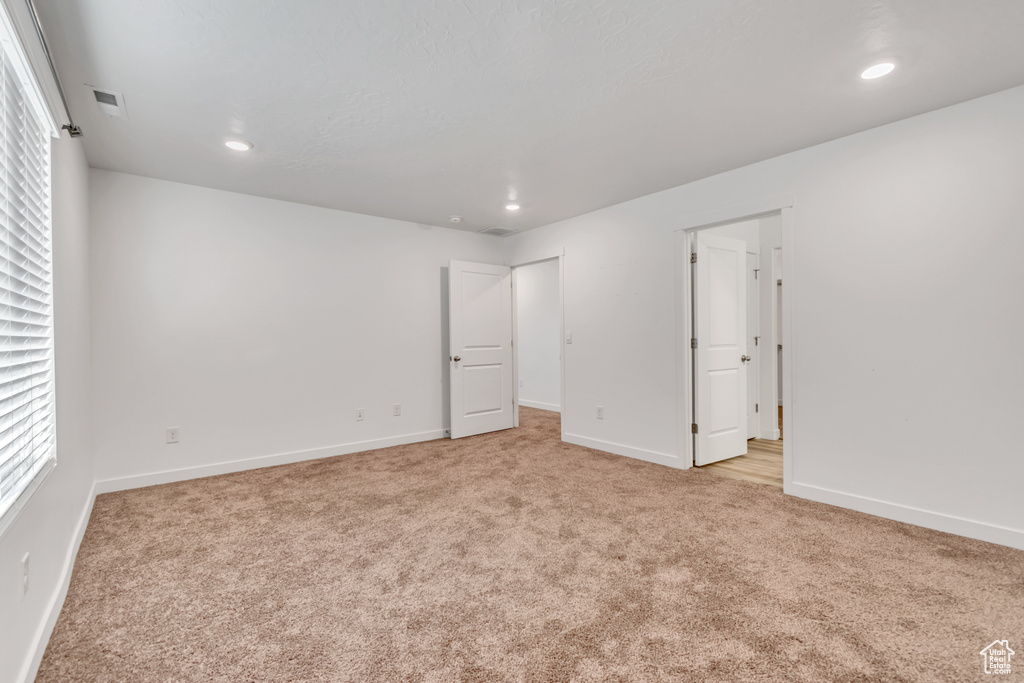 Unfurnished bedroom with carpet, baseboards, recessed lighting, and multiple windows