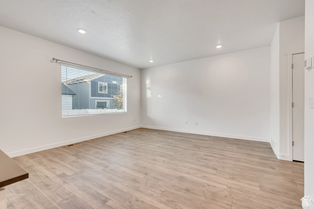Unfurnished room with light wood-type flooring, baseboards, and recessed lighting