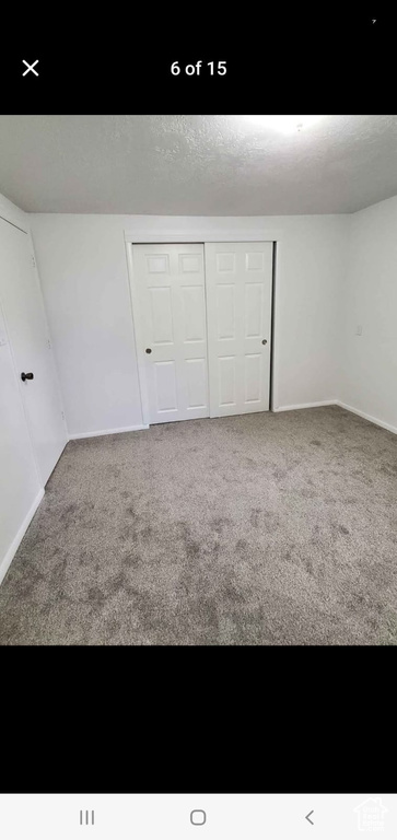 Unfurnished bedroom featuring carpet, baseboards, and a closet