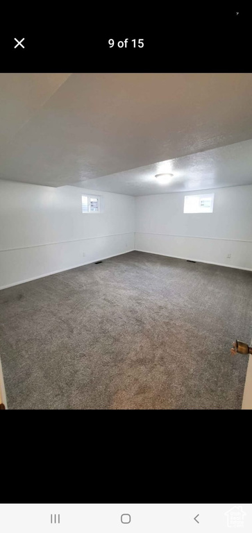 Carpeted empty room featuring vaulted ceiling