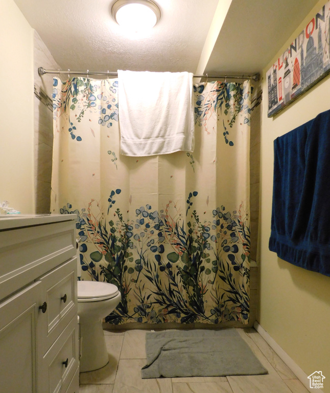 Full bath with vanity, toilet, and baseboards