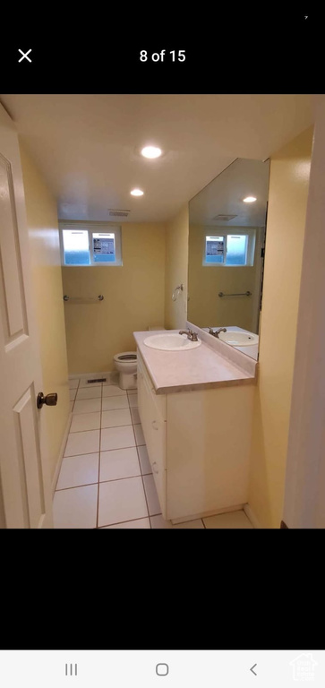 Bathroom featuring vanity, toilet, tile patterned floors, plenty of natural light, and recessed lighting