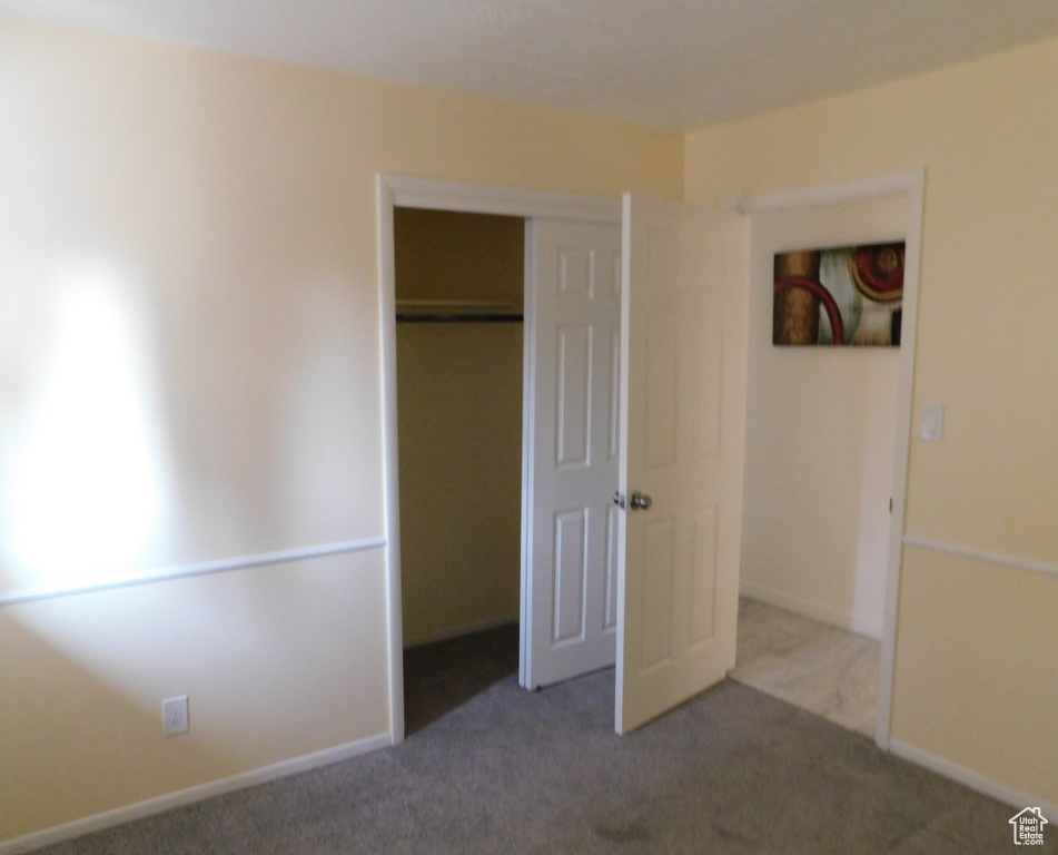 Unfurnished bedroom featuring carpet floors, a closet, and baseboards