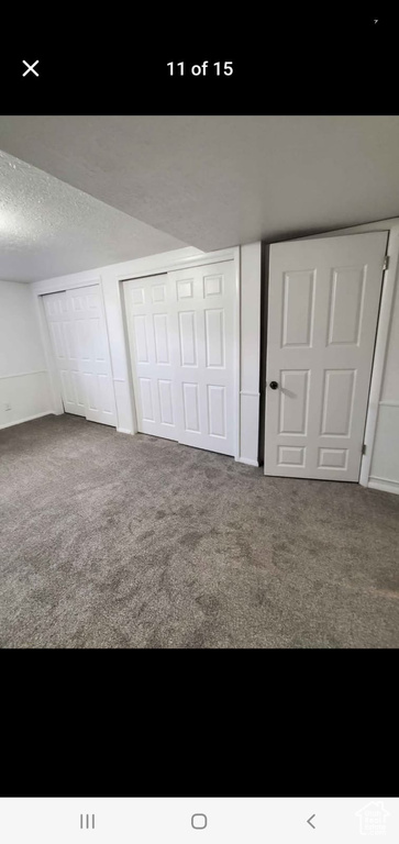 Unfurnished bedroom featuring carpet floors and a textured ceiling