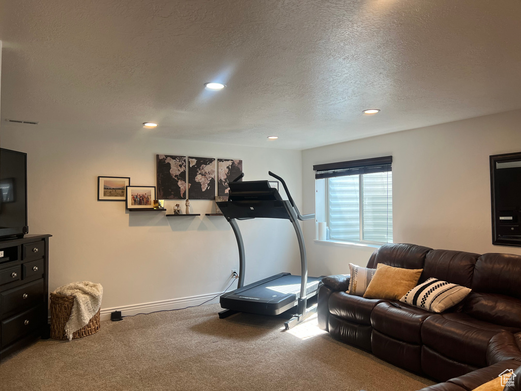 Exercise area with carpet, a textured ceiling, recessed lighting, and baseboards
