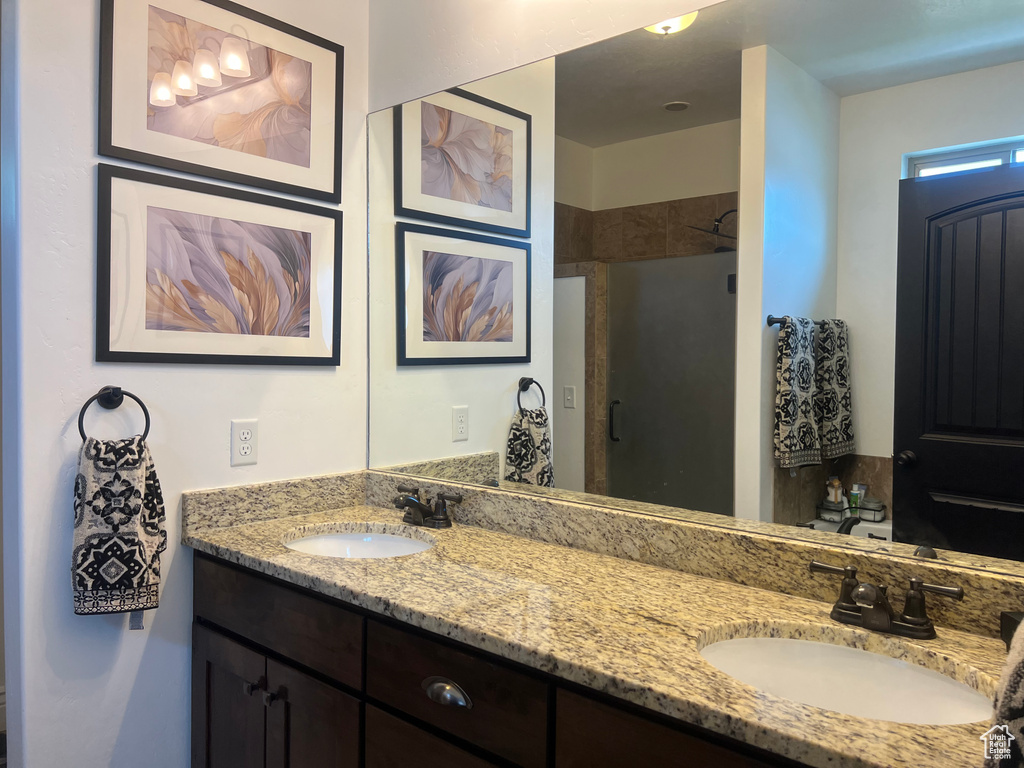 Full bath featuring double vanity and a stall shower