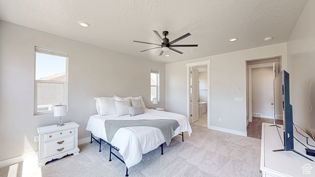 Bedroom featuring light colored carpet, multiple windows, recessed lighting, a textured ceiling, and baseboards