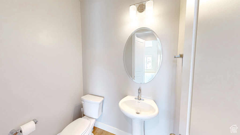 Bathroom with toilet and wood finished floors
